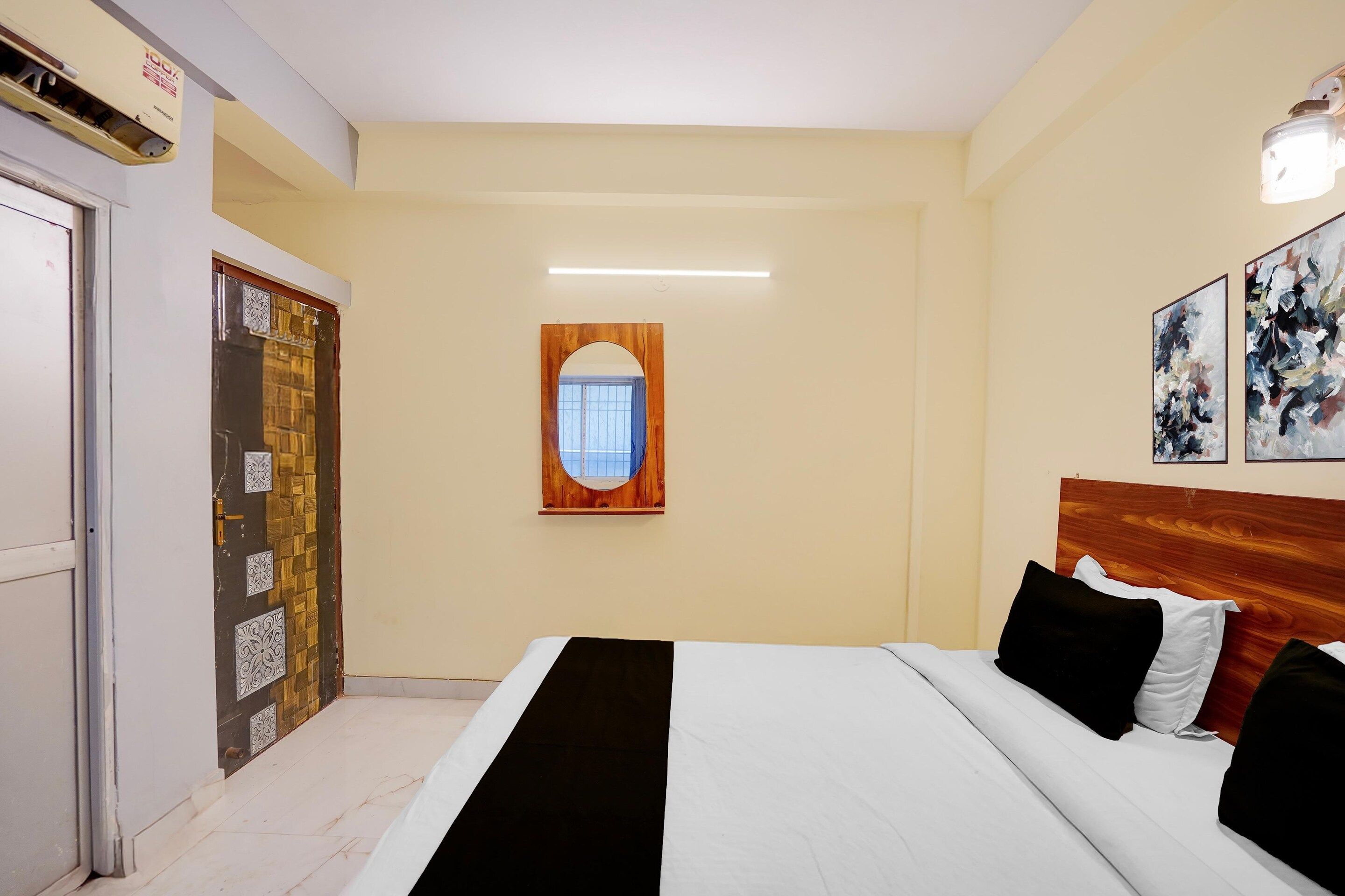A hotel room with a bed, a window, and a door.
