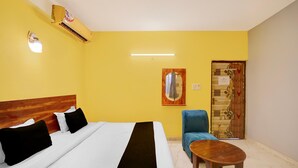 Ett hotellrum med en säng, en stol, ett litet bord och en dörr med en dekorativ panel.