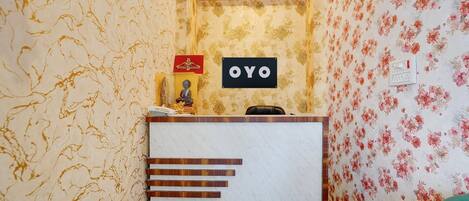 A reception area with a marble counter, a clock, and a sign that reads 'OYO'.