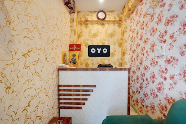 A reception area with a marble counter, a clock, and a sign that reads 'OYO'.
