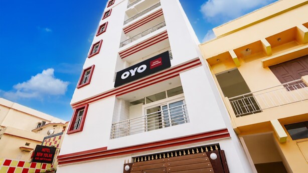 En hotellbyggnad med flera våningar, ett tydligt synligt "OYO"-skylt, balkonger och en grind vid ingången.