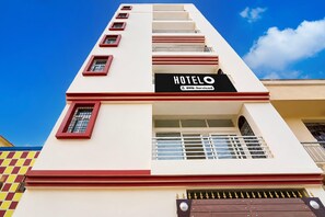 A hotel building with a sign that reads 'HOTEL OYO-Serviced' and a gated entrance. - Classic Hotel Newyork (Patna)