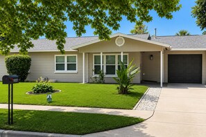 A residential house with a front yard, mailbox, and garage. - 4-bedroom house in perfect Cocoa with cool AC for relaxing stays (Cocoa)