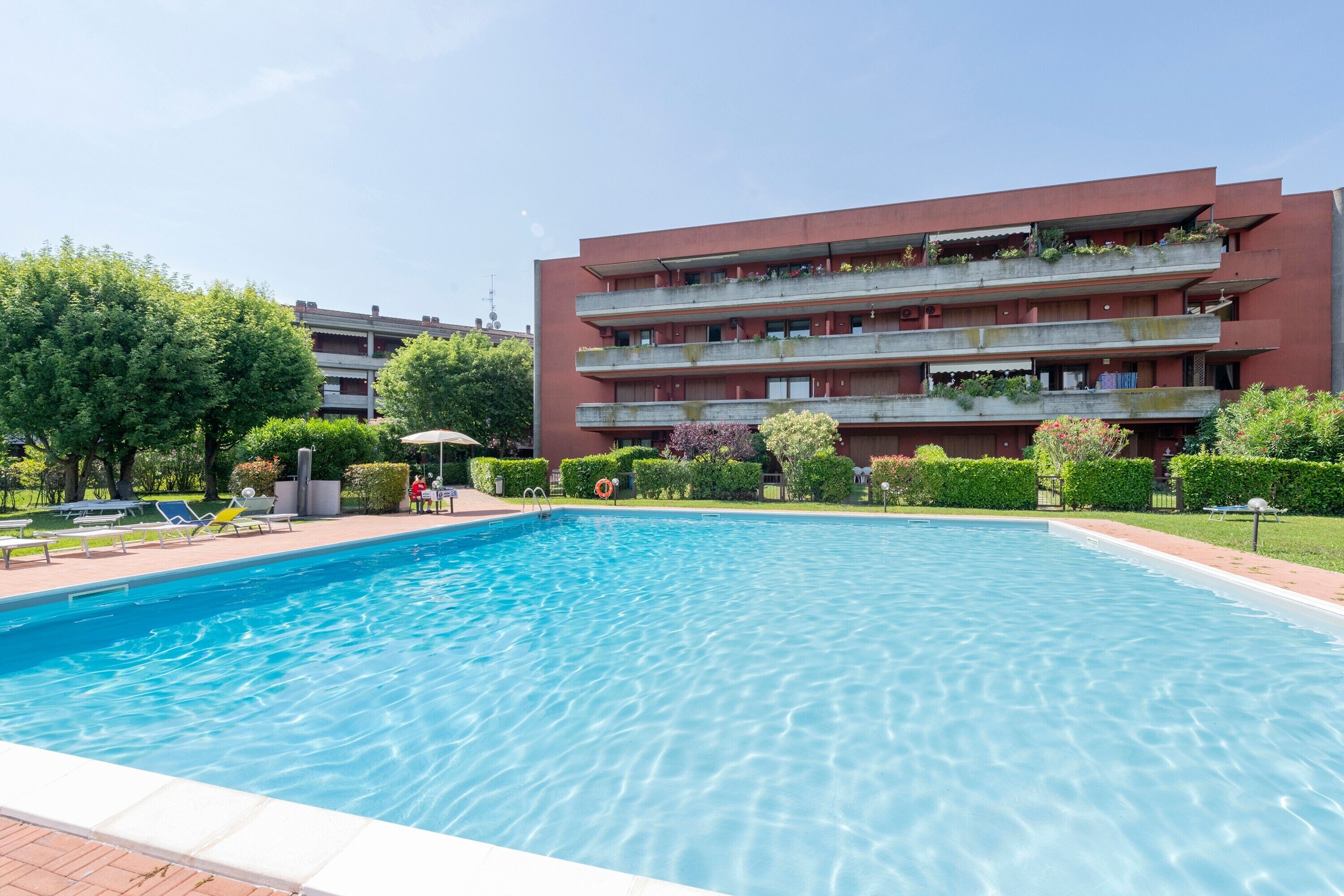 Una piscina con un edificio rojo al fondo.
