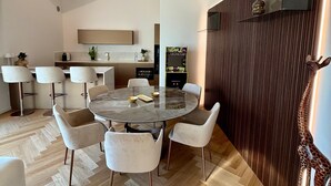 Een moderne eetruimte met een ronde tafel, witte stoelen en een houten visgraatvloer.