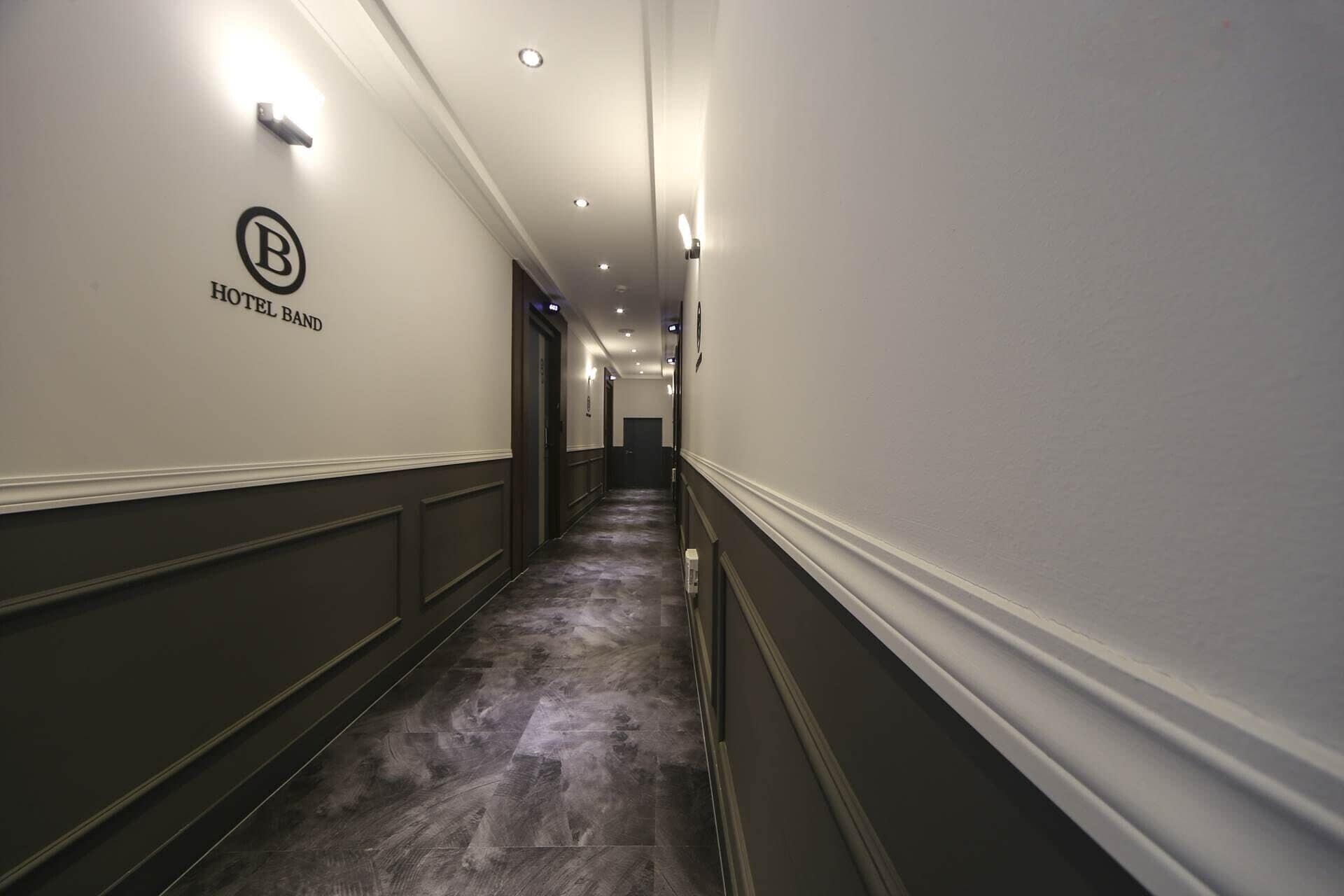 A hotel corridor with a sign indicating 'HOTEL BAND' on the wall.