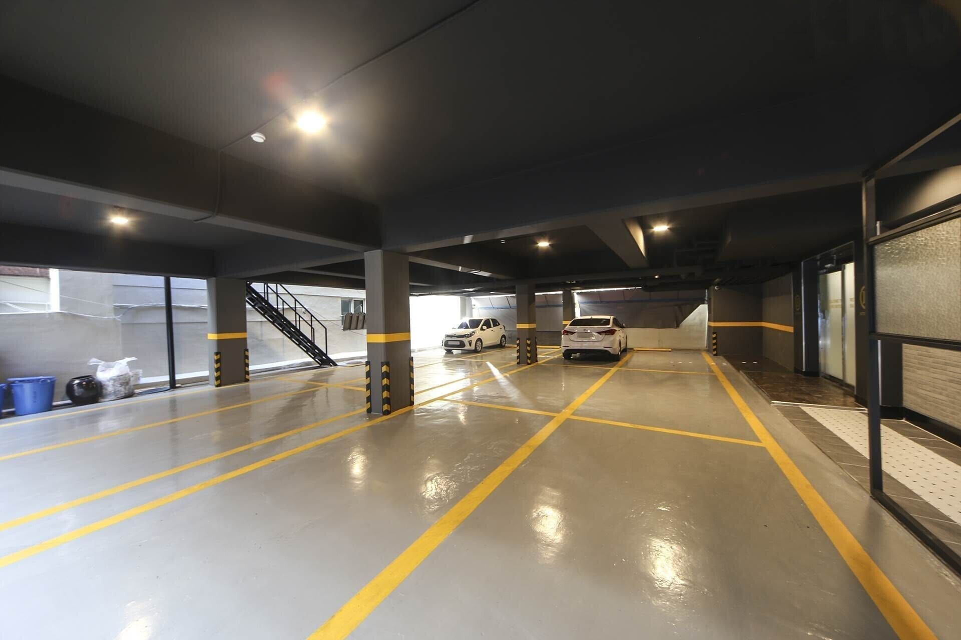 A multi-level parking garage with clear lane markings and a staircase leading to an upper level.