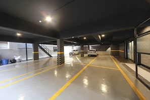 A multi-level parking garage with clear lane markings and a staircase leading to an upper level.