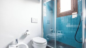 Ein Badezimmer mit Bidet, Toilette und einer Duschkabine.