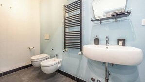 Un baño con inodoro, bidé y lavamanos.