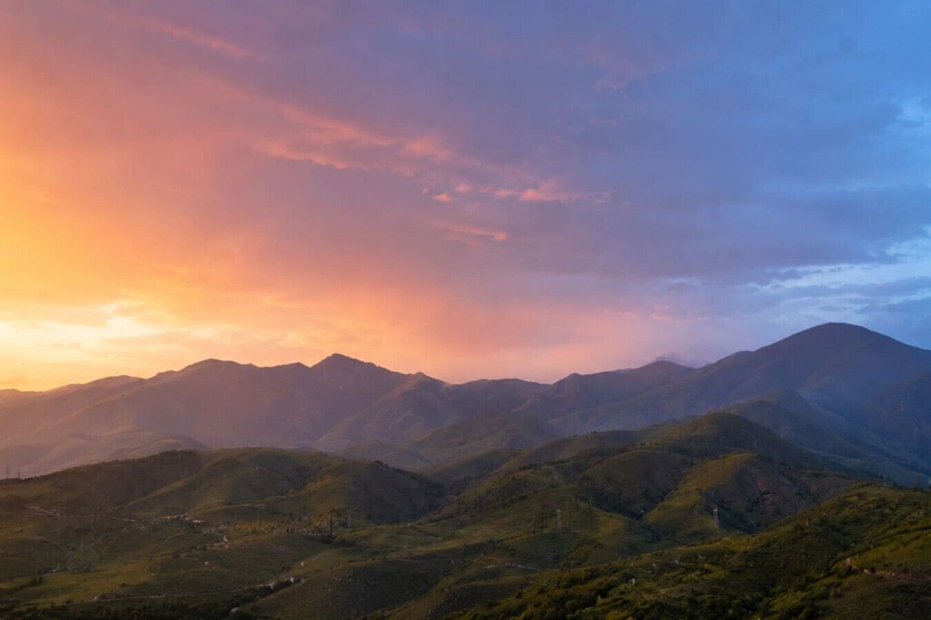 Un paisaje montañoso con colinas ondulantes y cielo despejado.