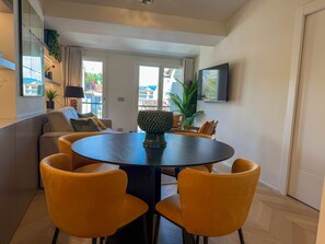 A modern dining area with a round table, yellow chairs, and a potted plant. - Genteel Home Campuccio Firenze (Florence)