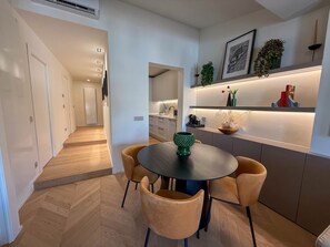 Eine moderne Küche mit Essbereich, Holzboden und einer eingebauten Ablagefläche mit Dekorationselementen.