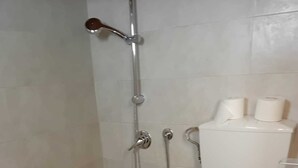 Un baño con ducha, inodoro y lavabo.