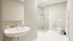Ein modernes Badezimmer mit Waschbecken, Spiegel und Duschkabine.