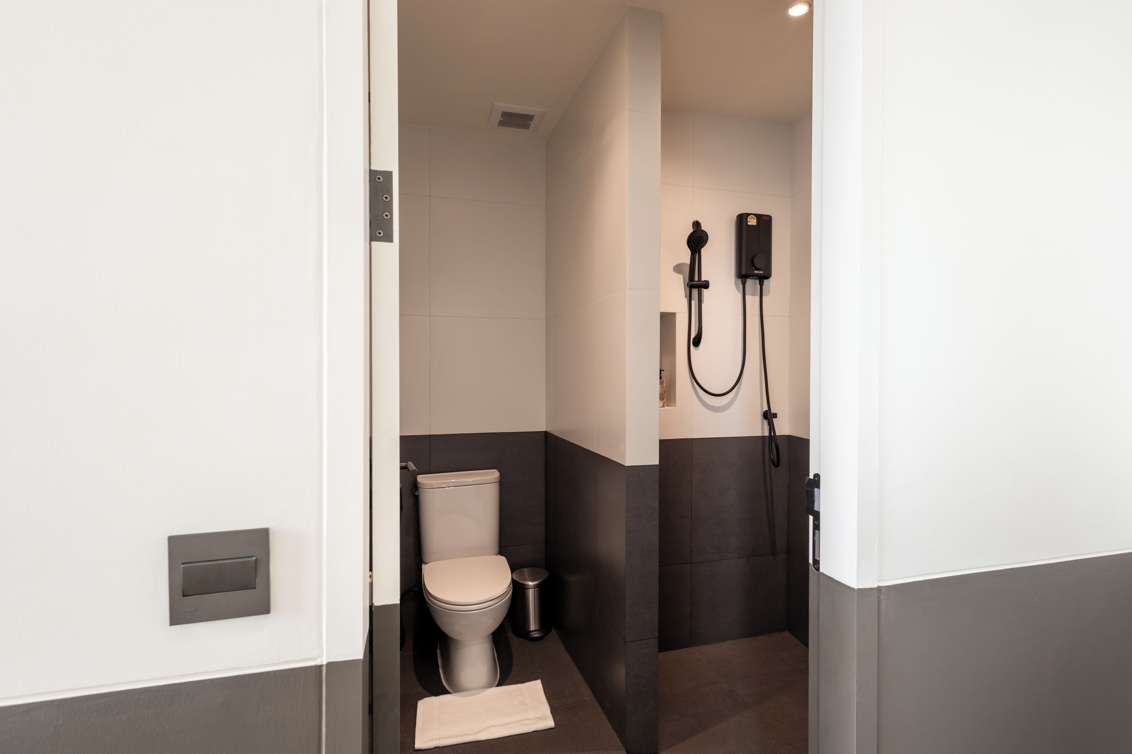 A modern bathroom with a toilet, bidet, and shower unit.