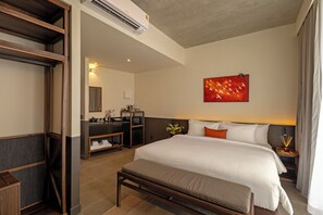 Una habitación de hotel con cama, mesita de noche y un cuadro en la pared.