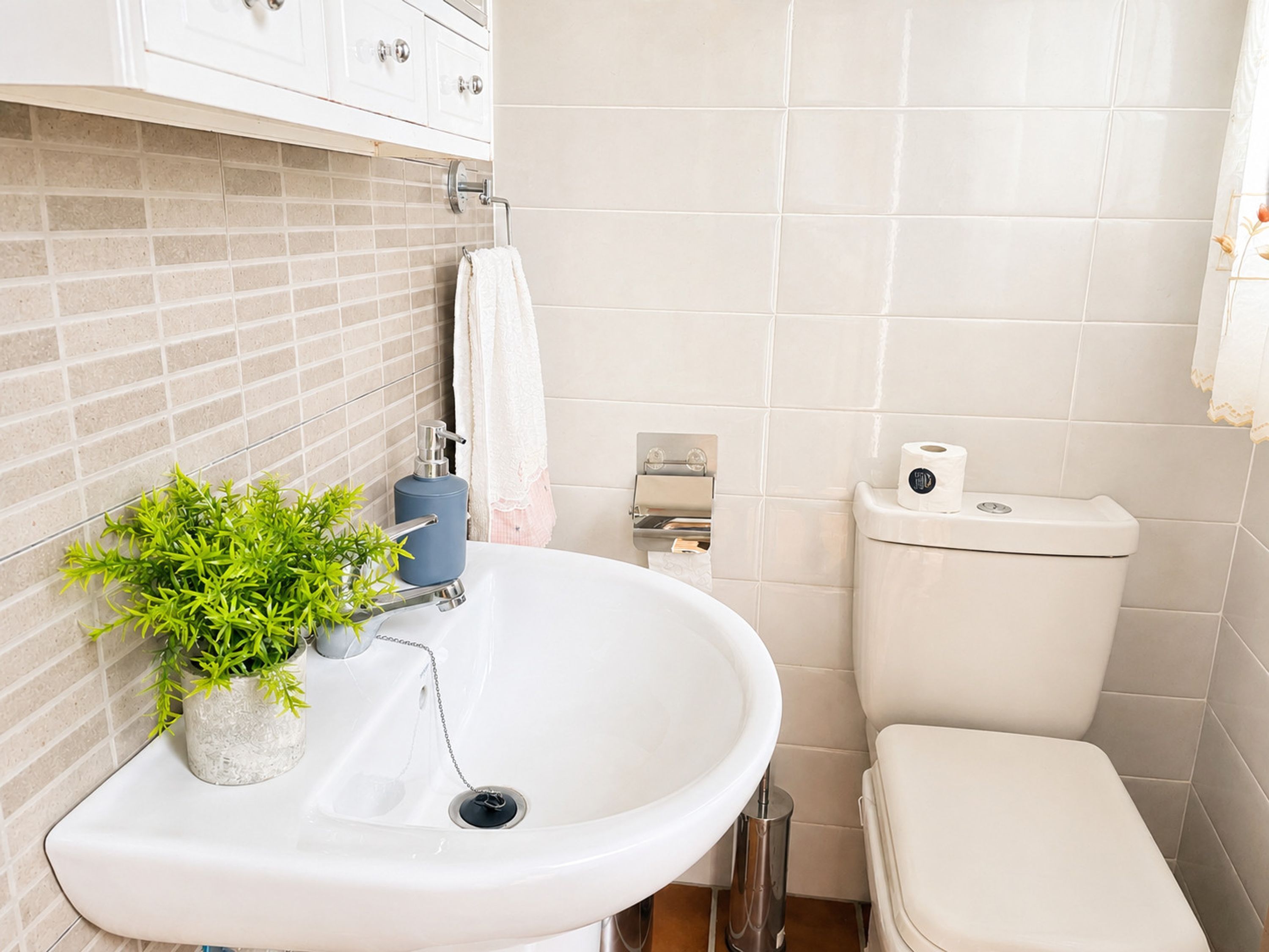 Un bagno con un lavandino bianco, un water e uno spazio doccia.