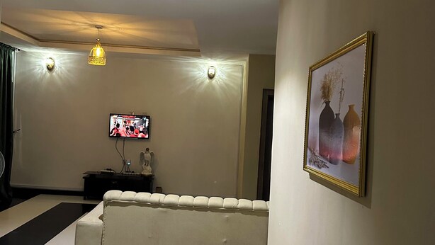 Una sala de estar con un sofá, un televisor y un cuadro en la pared.
