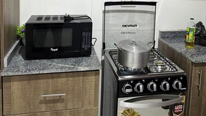 Una cocina con microondas, estufa y armarios.