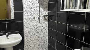 Un baño con lavamanos, inodoro, ducha y ventana con vistas.