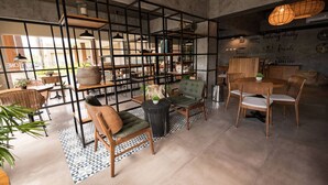 Ein modernes Interieur mit einer zentralen Sitzecke, einer Kaffeebar und einer sichtbaren Speisekarte an der Wand.