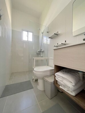 Un baño moderno con inodoro, ducha y toallero.