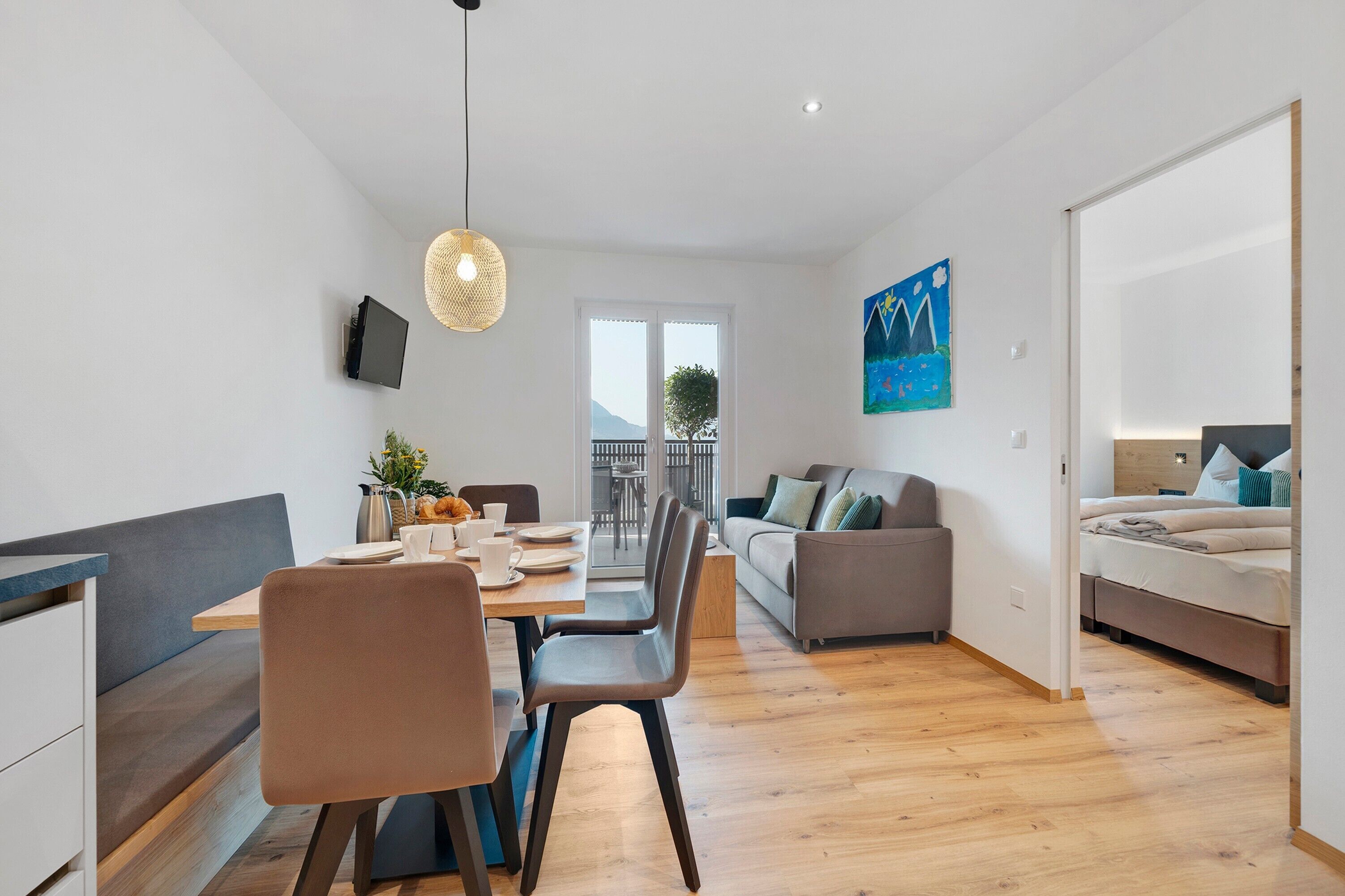 Un appartamento moderno con zona pranzo, divano e letto.