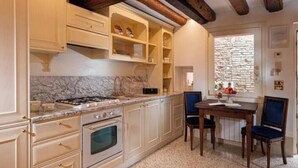Uma cozinha com bancadas de mármore, armários de madeira e uma parede de pedra.
