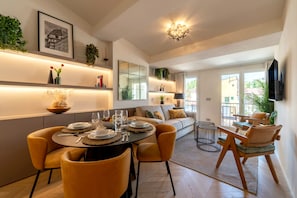 Uma sala de jantar moderna com mesa redonda, cadeiras e um sofá.
