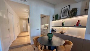 Eine moderne Küche mit Essbereich, Holzboden und einer eingebauten Vitrine mit Dekoration.