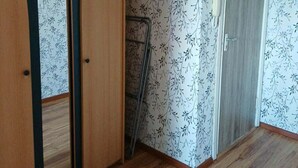 A room with a wardrobe, a door, and patterned wallpaper. - 2-bedroom apartment in lovely Ventspils with air conditioning 1 (Ventspils)