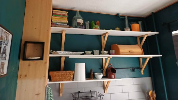 A kitchen with wooden shelves, a hanging rack, and various kitchen items. - 2-bedroom apartment in lovely Ventspils with air conditioning 1 (Ventspils)
