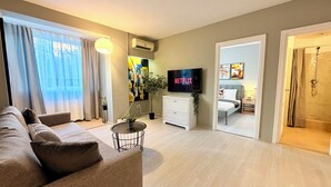 Een moderne woonkamer met een bank, een televisie en een potplant.