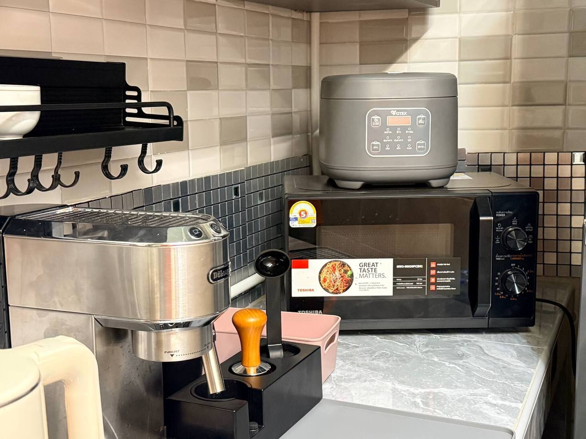 A kitchen with a toaster, a rice cooker, and a microwave.
