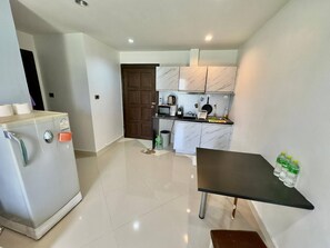A compact kitchen with a refrigerator, a microwave, a sink, and a small dining table. - Heaven of Pattaya!!! (Pattaya)