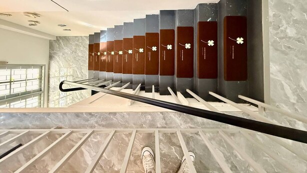 A staircase with a handrail, a series of vertical panels with floral designs, and a marble floor. - Heaven of Pattaya, Entire Private 2 Floors, 3 Bedrooms for big Families! (Pattaya)