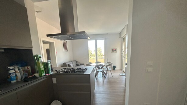 Een moderne keuken met een centraal eiland, een eethoek met stoelen en uitzicht op de omgeving.