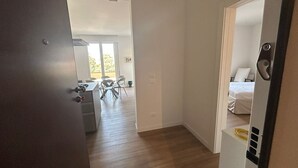 Een hotelkamer met een bed, een bureau en een stoel. Er is een balkon met een tafel en stoelen.