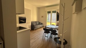 Uma cozinha moderna com forno embutido e um espaço de refeições com mesa e cadeiras.