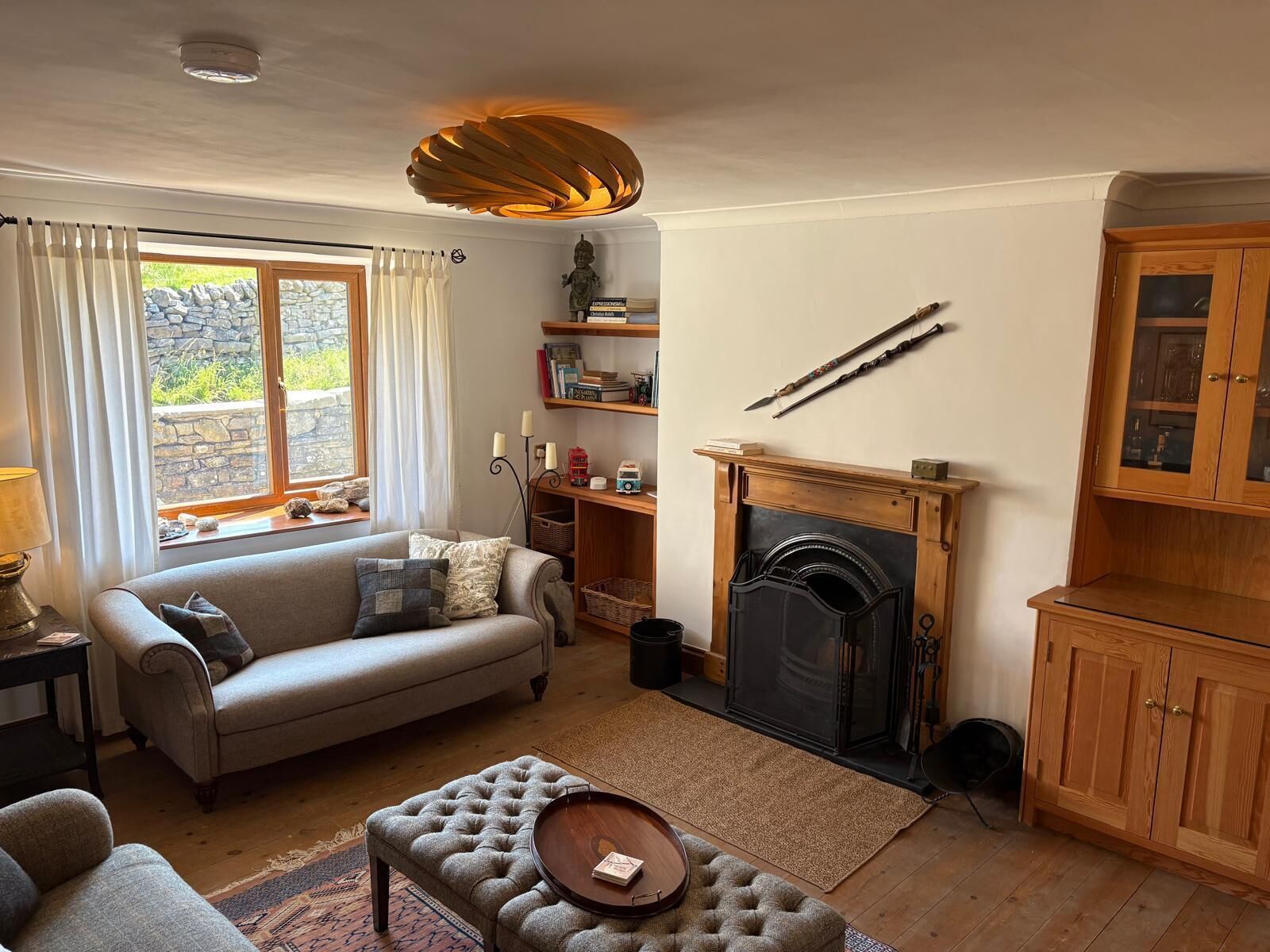 A cozy living room with a fireplace, a sofa, a coffee table, and a bookshelf.