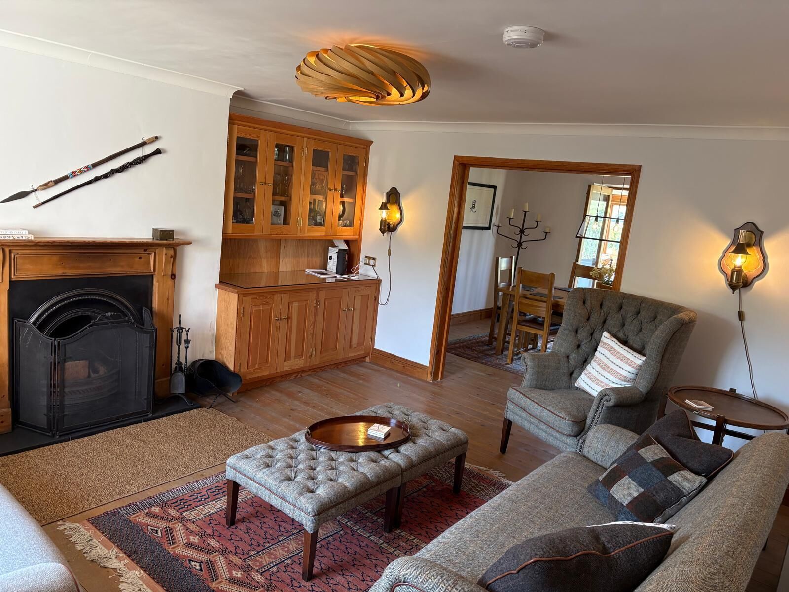 A living room with a fireplace, a dining area with wooden cabinets, and a cozy seating arrangement.