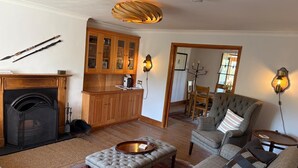 Una sala de estar con chimenea, un comedor con armarios de madera y una zona de estar acogedora.
