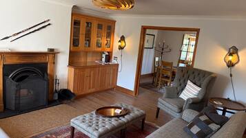 A living room with a fireplace, a dining area with wooden cabinets, and a cozy seating arrangement.