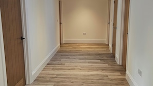 A hallway with wooden flooring, white walls, and a skylight. - Luxury Kent Bungalow Retreat Sleeps 12 (Tonbridge)