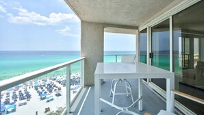 A balcony with a view of the beach, a white table, and a chair. - Luxury 3BR Beachfront Condo - Wrap Balcony, Endless Gulf Views! Pool & Beach! (Miramar Beach)
