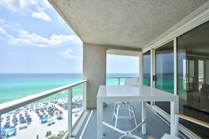 A balcony with a view of the beach, a white table, and a chair. - Luxury 3BR Beachfront Condo - Wrap Balcony, Endless Gulf Views! Pool & Beach! (Miramar Beach)