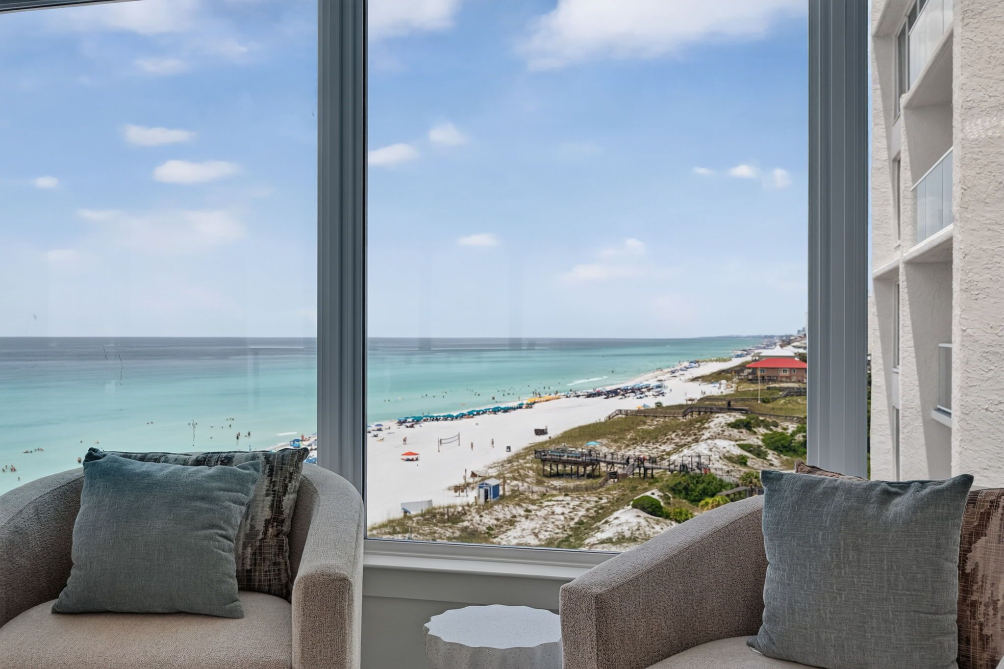 A view from a window overlooking a beach with a clear sky.