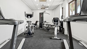 A gym with treadmills, weight machines, and a ceiling fan. - Luxury 3BR Beachfront Condo - Wrap Balcony, Endless Gulf Views! Pool & Beach! (Miramar Beach)