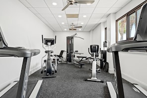 A gym with treadmills, weight machines, and a ceiling fan. - Luxury 3BR Beachfront Condo - Wrap Balcony, Endless Gulf Views! Pool & Beach! (Miramar Beach)